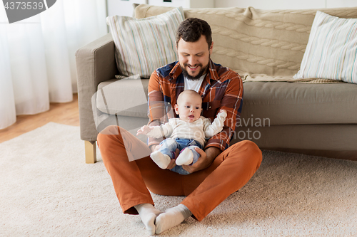 Image of happy father with little baby boy at home