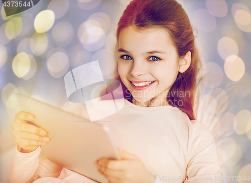 Image of happy girl in bed with tablet pc over lights