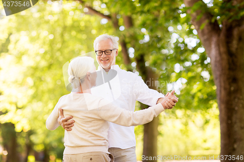 Image of happy senior couple dancing at summer park