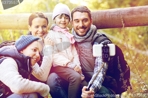 Image of family with backpacks taking selfie and hiking