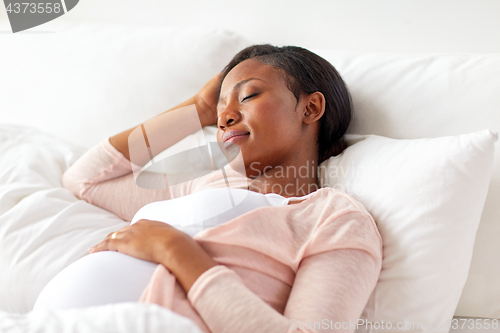 Image of pregnant african american woman sleeping at home