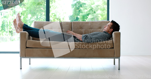 Image of Man using laptop in living room