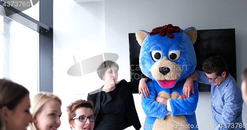 Image of boss dresed as bear having fun with business people in trendy of