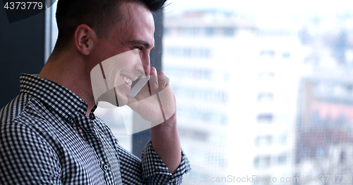 Image of Business Man Talking On Cell Phone, Looking Out Office Window