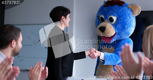 Image of boss dresed as bear having fun with business people in trendy of