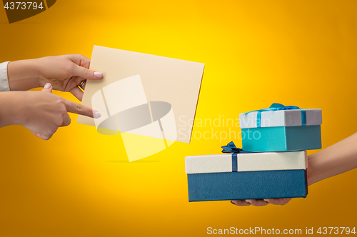 Image of The closeup picture of man and woman\'s hands with gift box