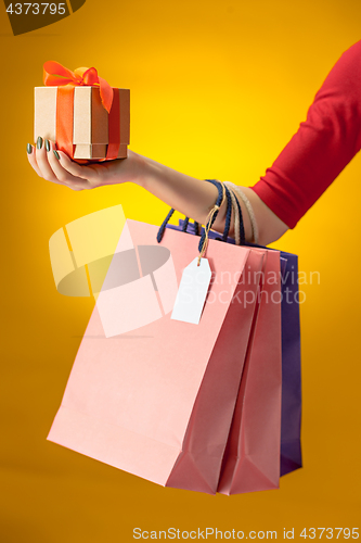 Image of Female hand holding bright shopping bags