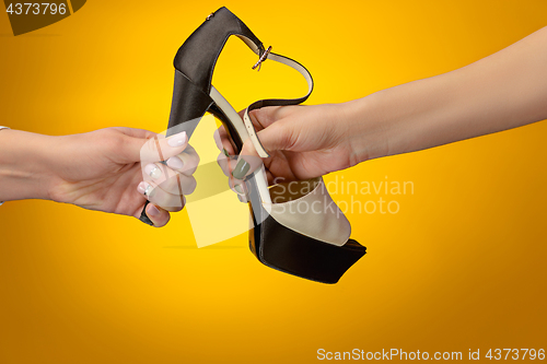 Image of Brown woman shoe with female and male on hands