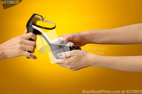 Image of Brown woman shoe with female and male on hands