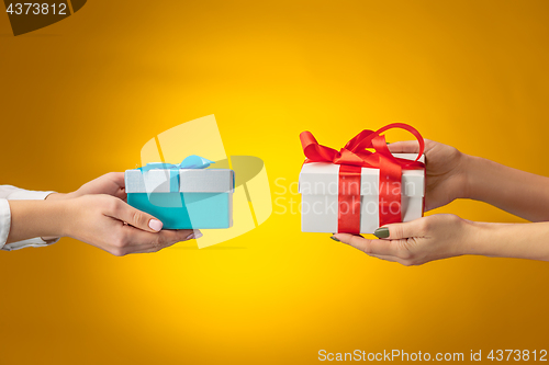 Image of The closeup picture of man and woman\'s hands with gift box