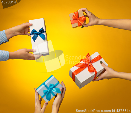 Image of The closeup picture of man and woman\'s hands with gift box