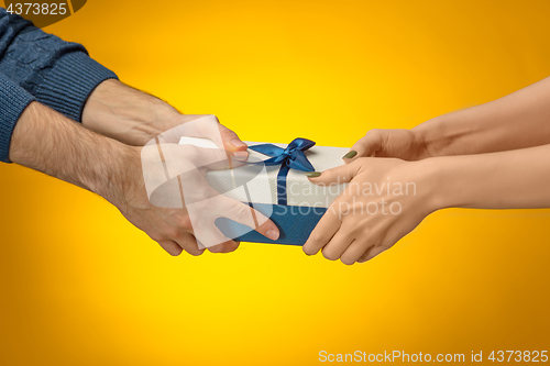 Image of The closeup picture of man and woman\'s hands with gift box