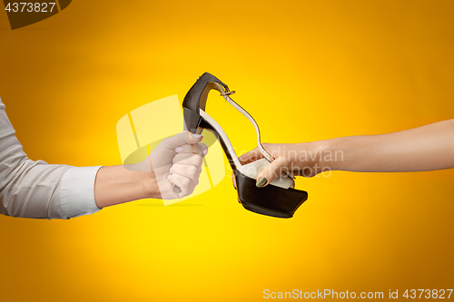 Image of Brown woman shoe with female and male on hands