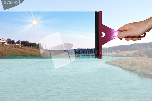 Image of A hand washes a dirty window