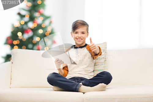 Image of boy with tablet pc showing thumbs up at christmas