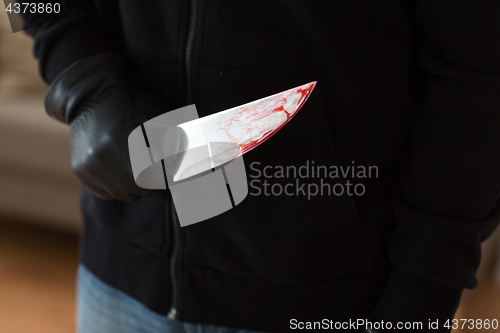 Image of close up of criminal with blood on knife