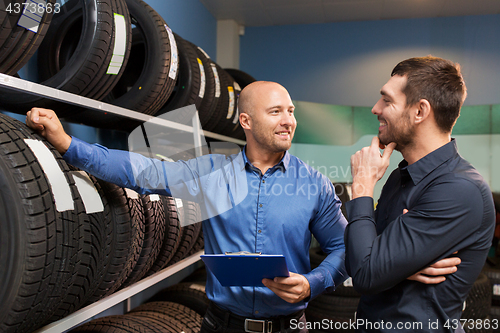 Image of customer and salesman at car service or auto store