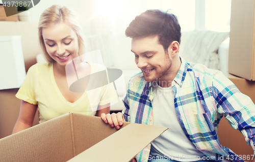 Image of smiling couple with big boxes moving to new home