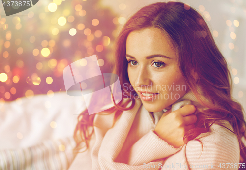 Image of happy young woman with plaid at home for christmas