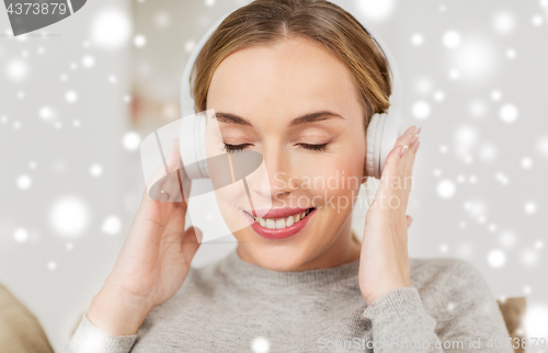 Image of woman with headphones listening to music at home