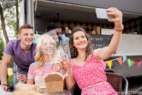 Image of happy young friends taking selfie at food truck