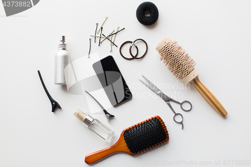 Image of smartphone, scissors, brushes and other hair tools