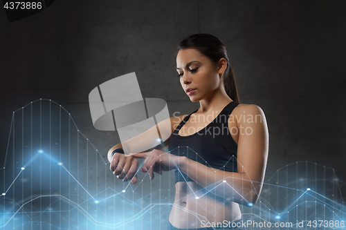 Image of young woman with heart-rate watch in gym