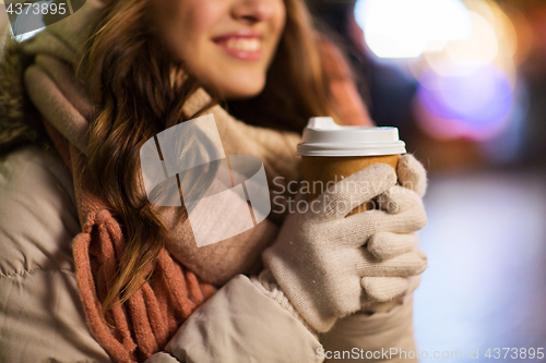 Image of happy woman with coffee over christmas lights