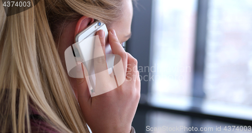 Image of Close up of business woman using cell phone in office interior