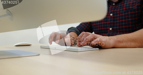 Image of hands typing on computer keyboard in startup office