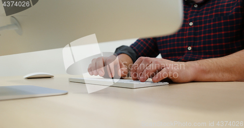 Image of hands typing on computer keyboard in startup office