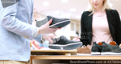 Image of Man Chooses Shoes At Shoe Store