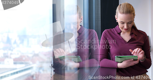 Image of Pretty Businesswoman Using Tablet In Office Building by window