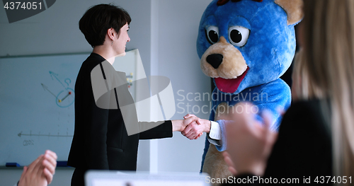 Image of boss dresed as bear having fun with business people in trendy of