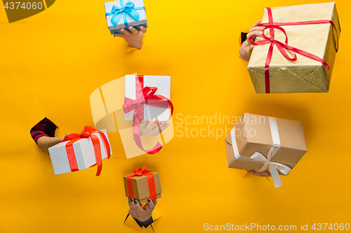 Image of close-up of female hand holding a present through a torn paper, isolated