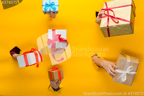 Image of close-up of female hand holding a present through a torn paper, isolated