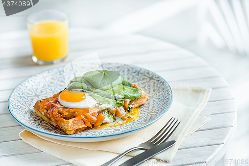 Image of Scrambled eggs on meat with fried potatoes and toast