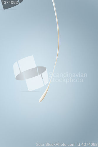 Image of Splash of milk or cream isolated on blue background