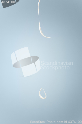 Image of Splash of milk or cream isolated on blue background