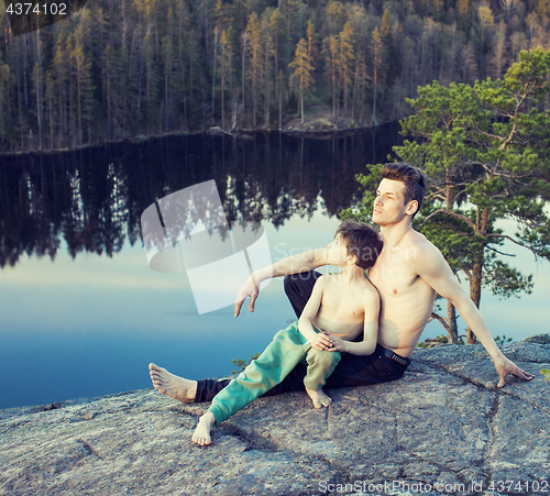 Image of middle age man with little cute son doing sport yoga on the top of the mountain together, happy family lifestyle people outdoor, summer wild nature for training 