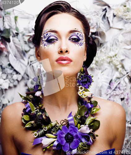 Image of floral face art with anemone in jewelry, sensual young brunette woman