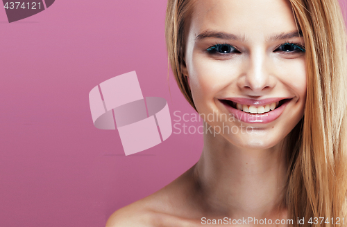 Image of young pretty blonde woman with hairstyle close up and makeup on pink background