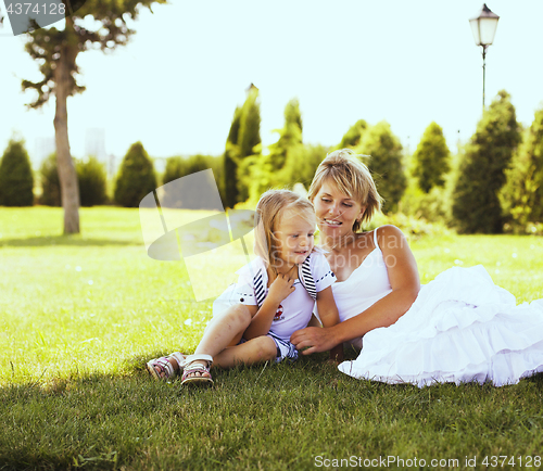 Image of mother with daughter having fun on grass