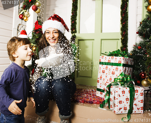 Image of happy family on Christmas in red hats waiting gests and smiling outdoor