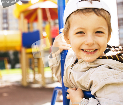 Image of little cute boy on swing outside