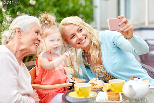 Image of happy family taking selfie at cafe