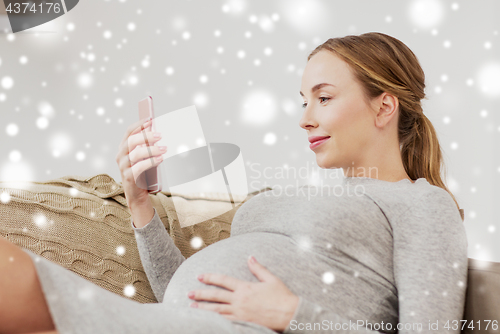 Image of happy pregnant woman with smartphone at home