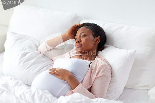 Image of pregnant woman lying in bed at home