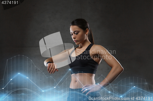 Image of young woman with heart-rate watch in gym