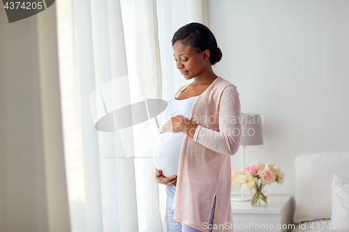 Image of pregnant african american woman at home window